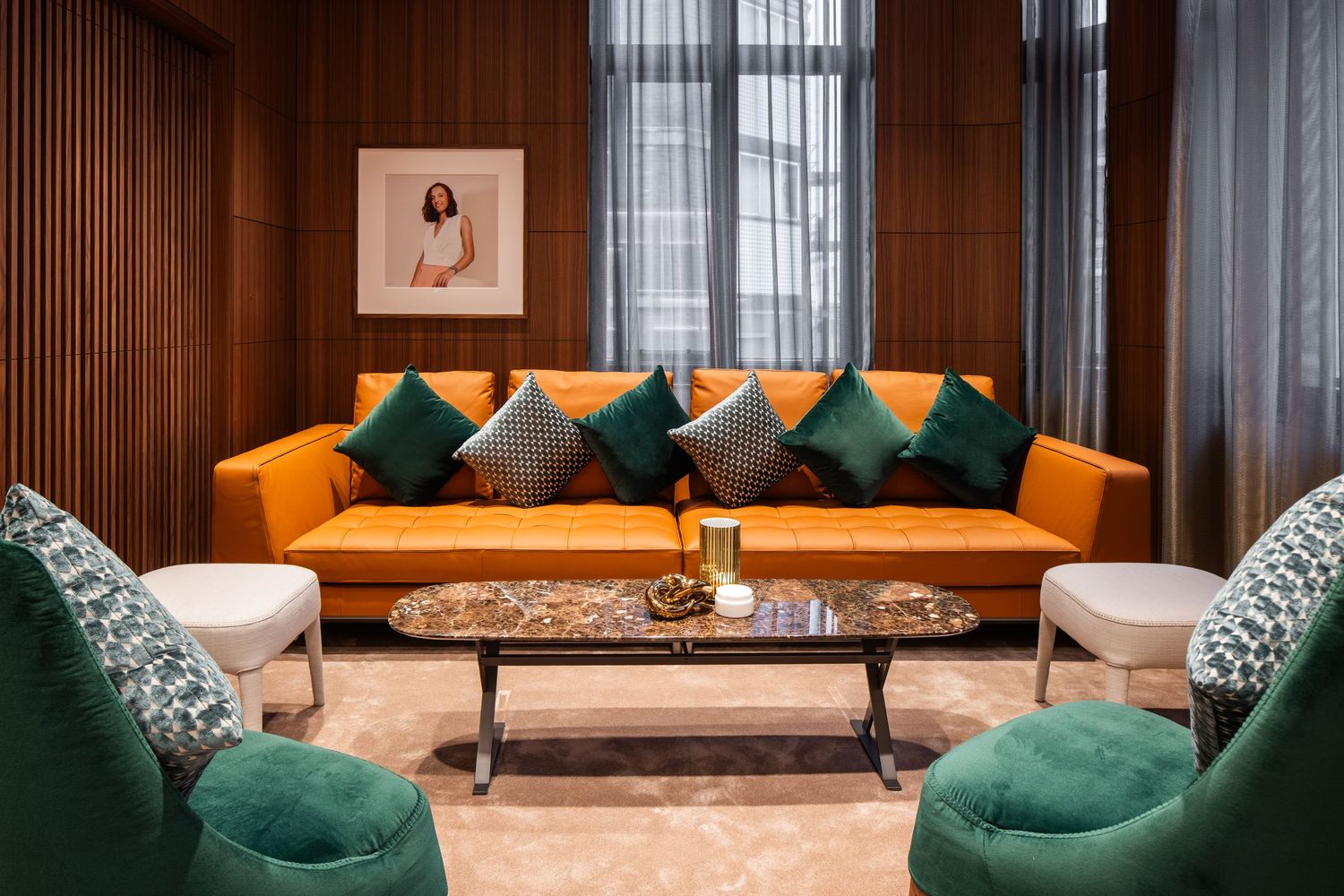 Modern luxury retail space with emerald green velvet seating and wood paneled walls.