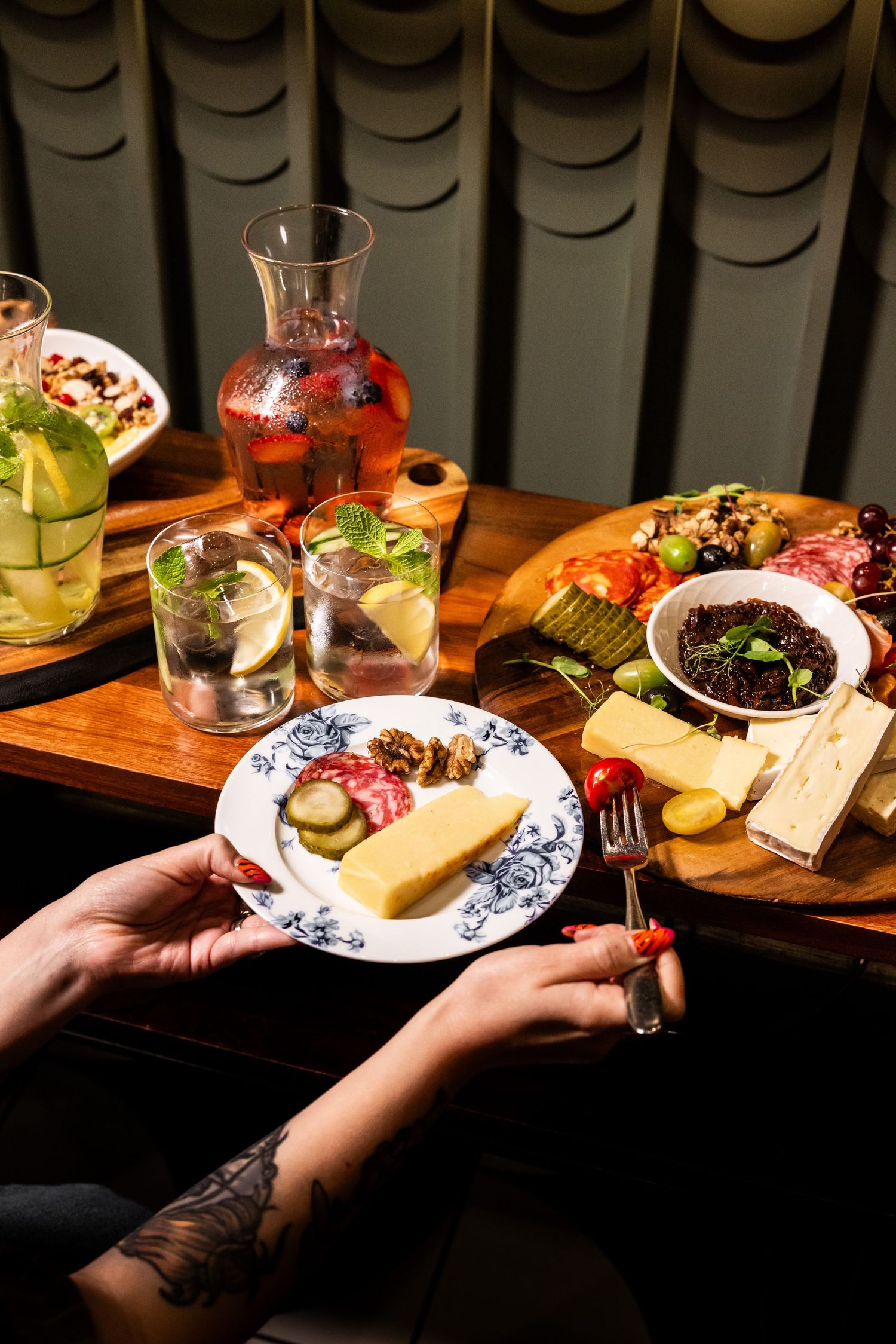 Artfully plated dishes and cocktails on wooden table with vintage blue and white china.