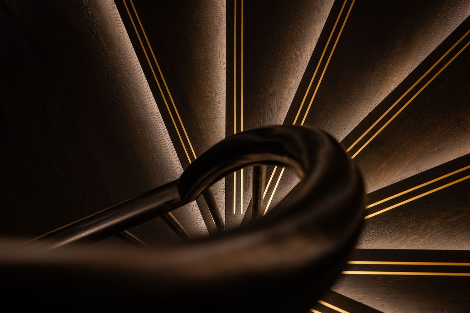 Abstract architectural lighting detail with gold metallic lines creating dramatic shadows.