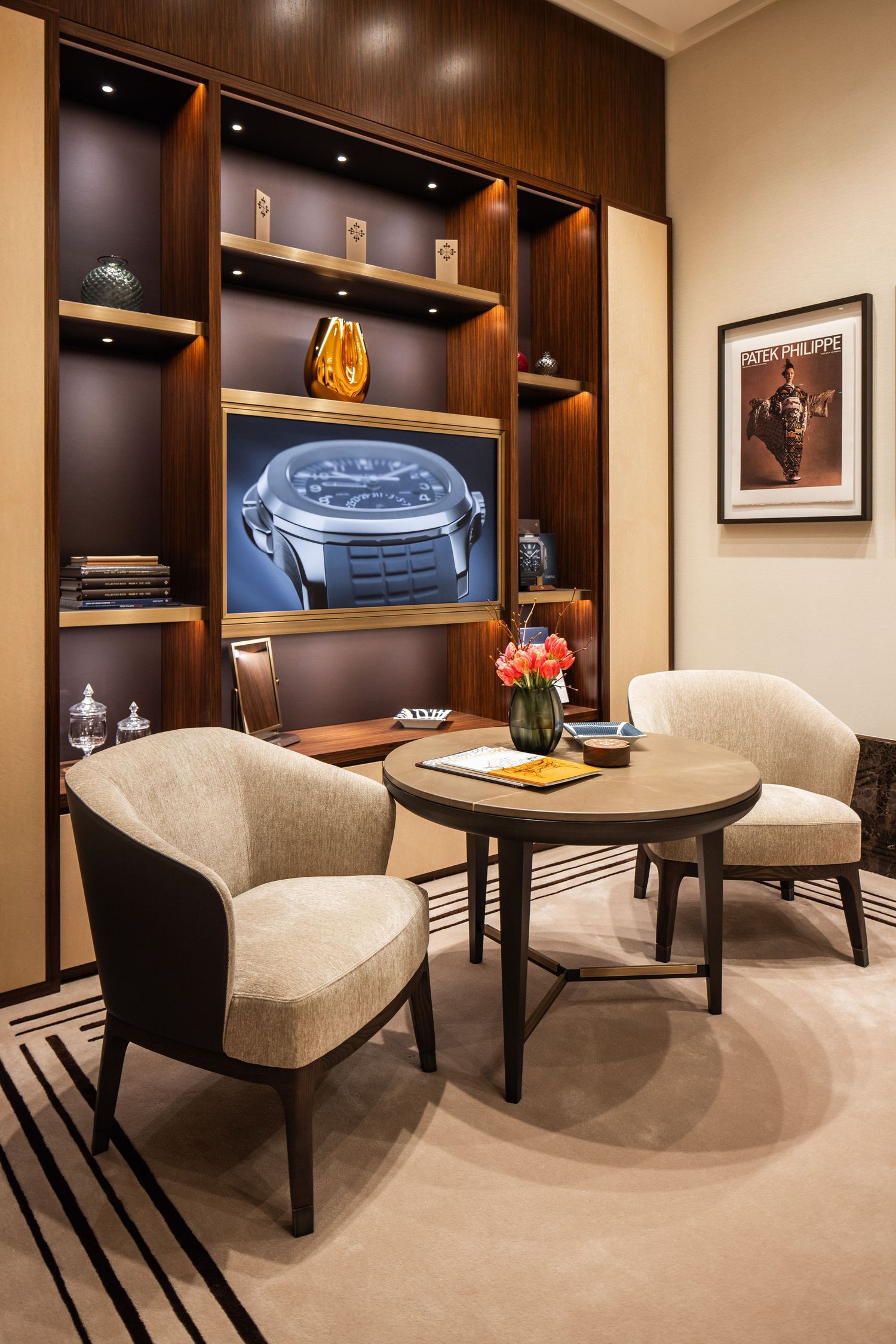 Luxurious seating area with built-in shelving and watch display in warm wood tones.