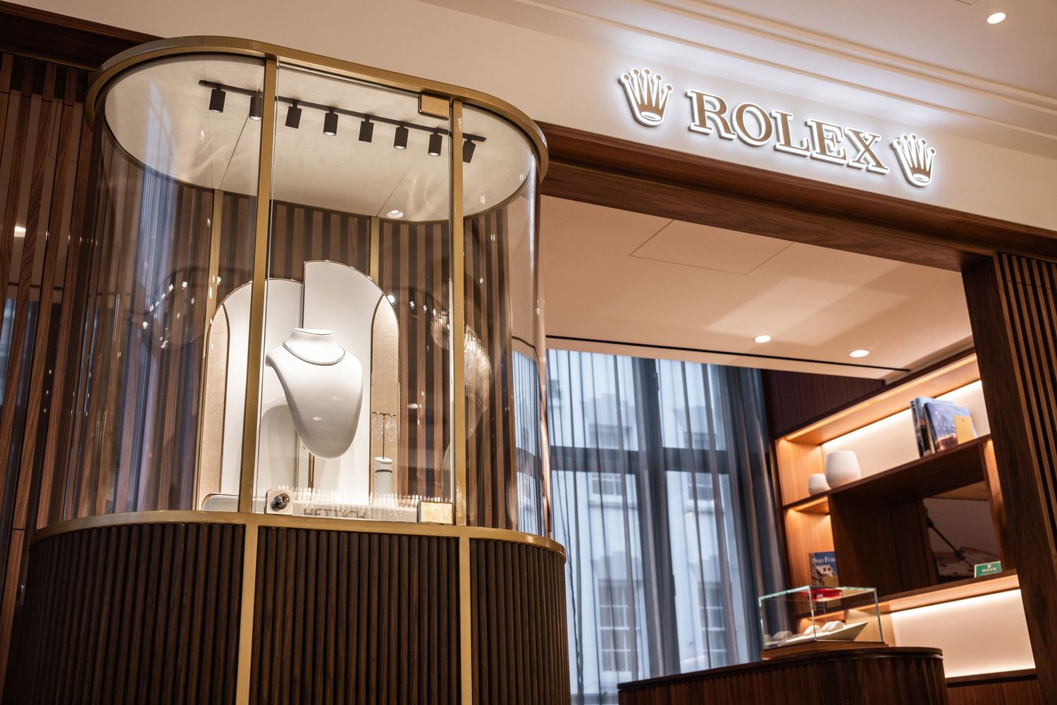Upscale watch boutique interior with illuminated Rolex branding and modern design elements.