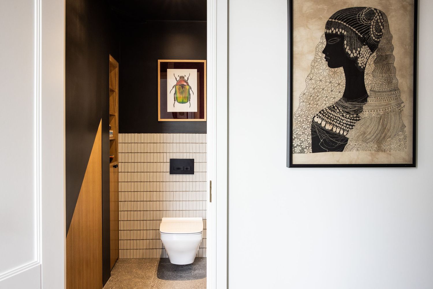 Contemporary hallway with white walls, framed artwork, and modern lighting fixtures.