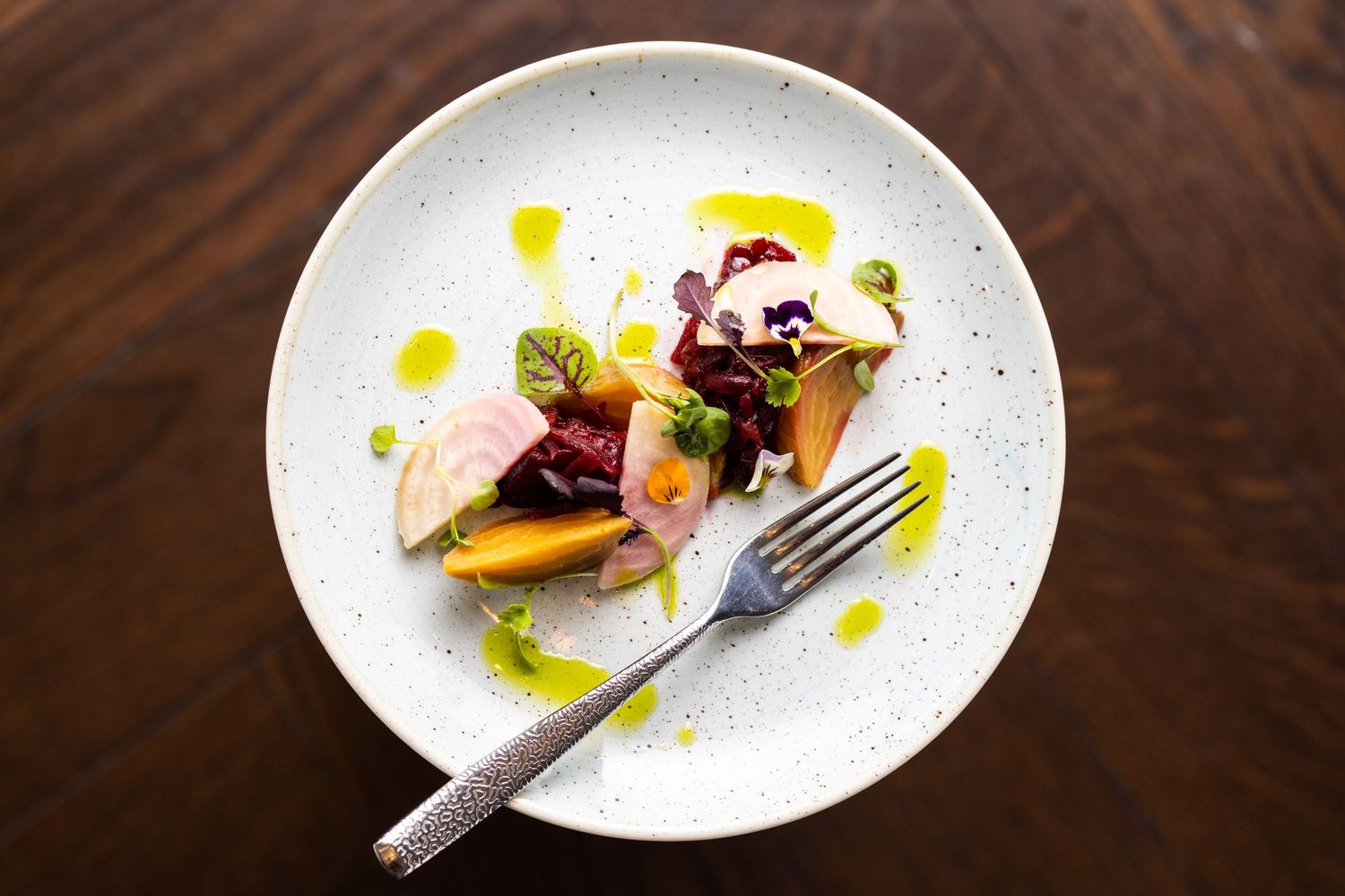 Artfully plated dishes on white ceramic plates with colorful garnishes and sauces.