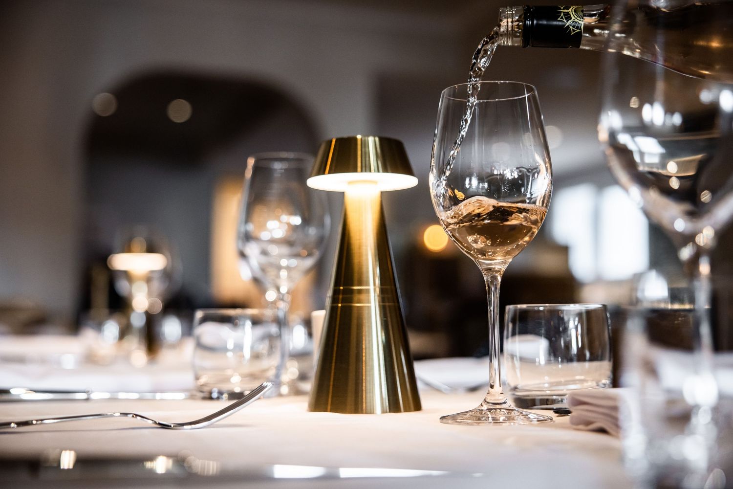 Fine dining table setting with wine glasses and ambient lighting creating an elegant atmosphere.