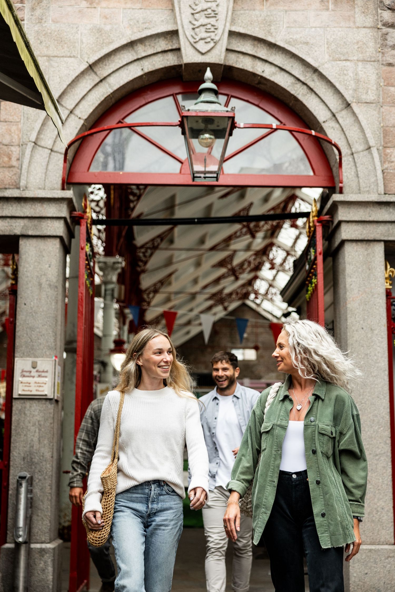 People walking under stone archways with historic architectural details.