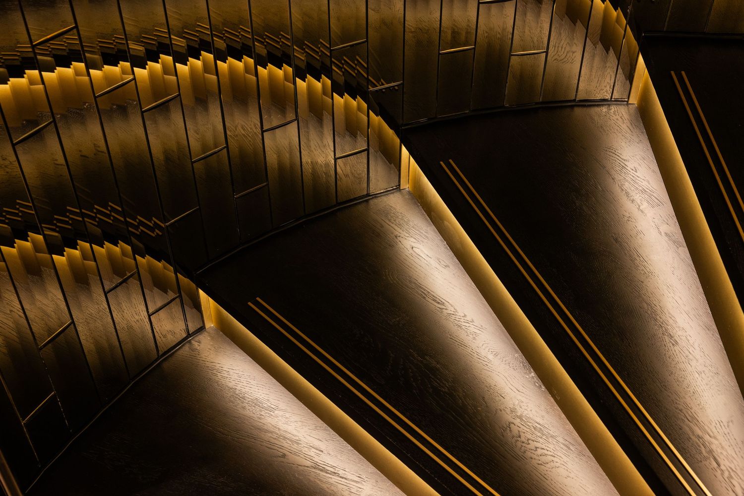 Ornate gold and crystal chandelier detail with dramatic lighting creates an elegant ceiling pattern.