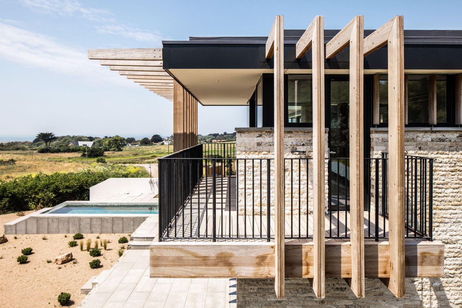 Contemporary building exterior featuring clean lines and wooden vertical supports against white facade.