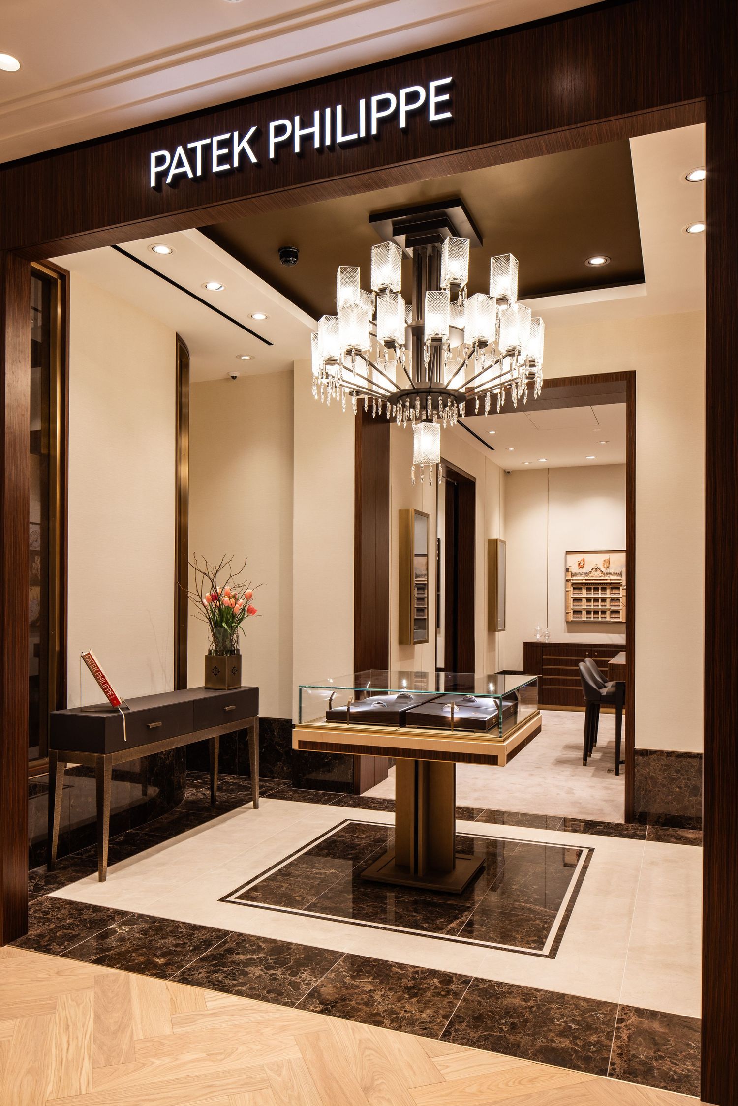Luxurious Patek Philippe boutique interior with elegant marble floors and crystal chandelier lighting.