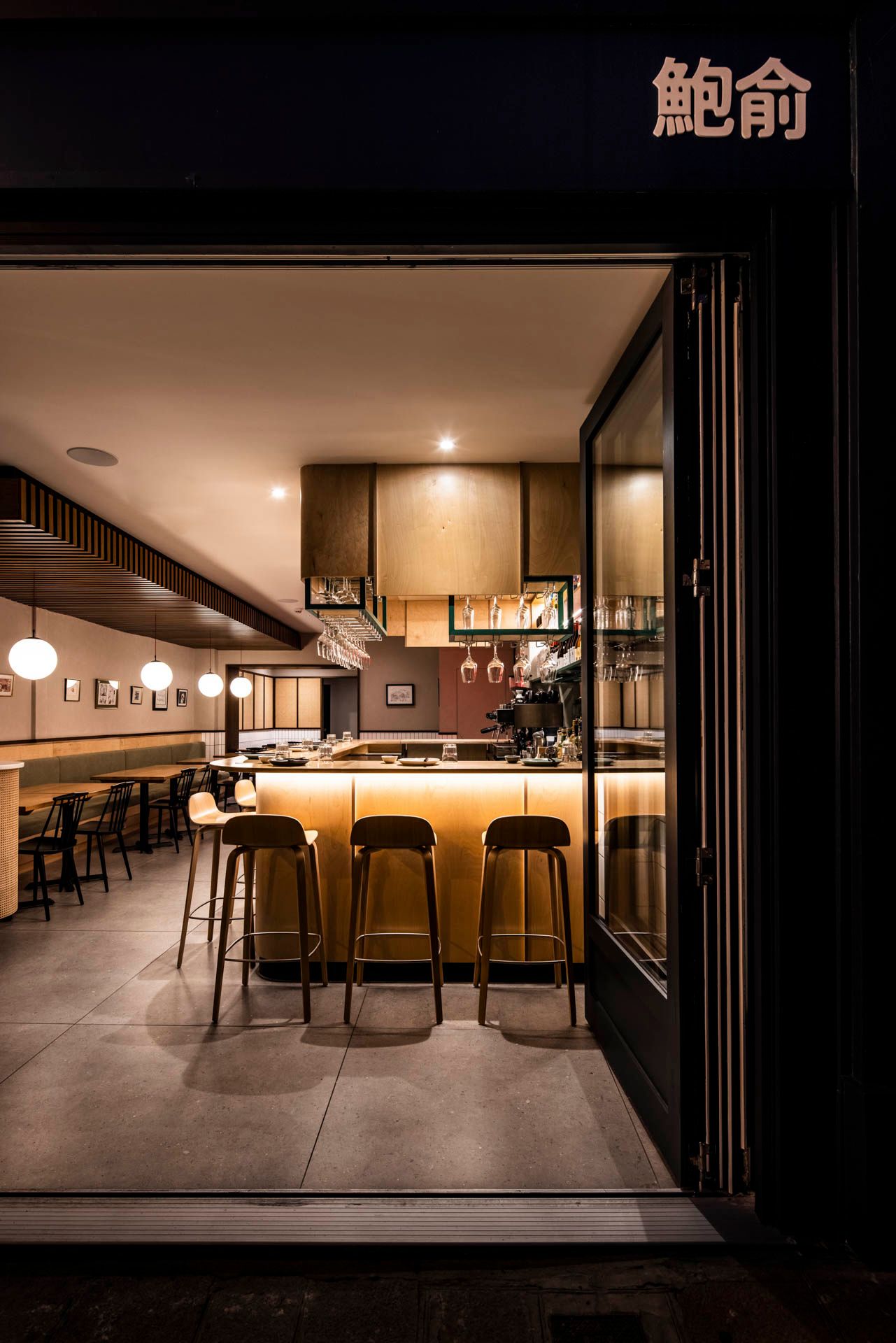 Warmly lit Japanese restaurant interior with modern bar seating and ambient lighting.