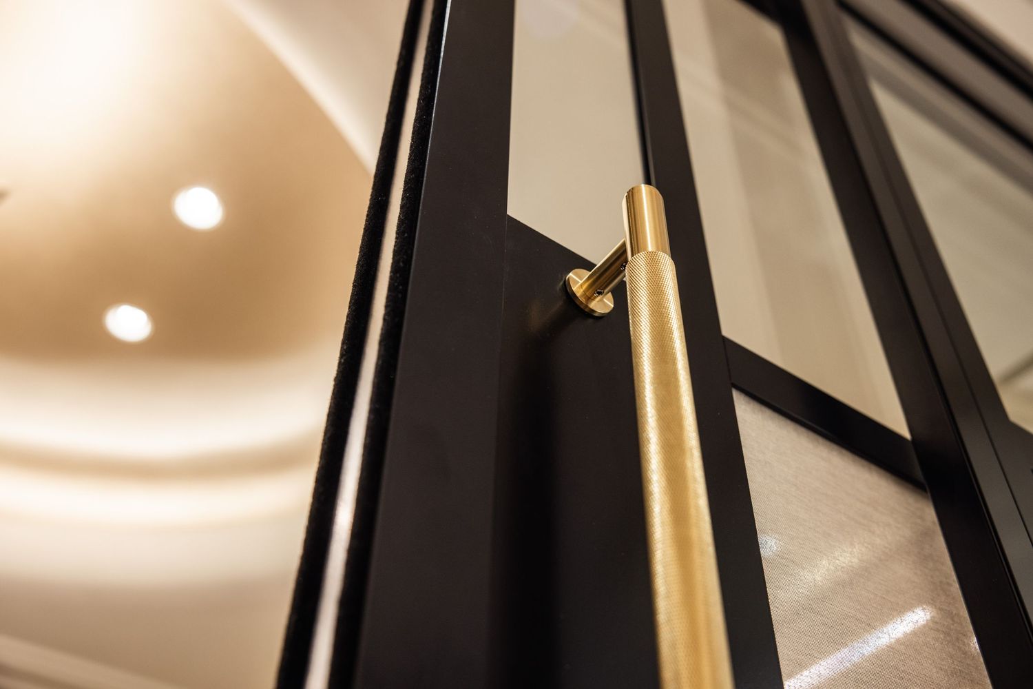 Abstract architectural detail showing black and gold geometric lines with soft lighting.