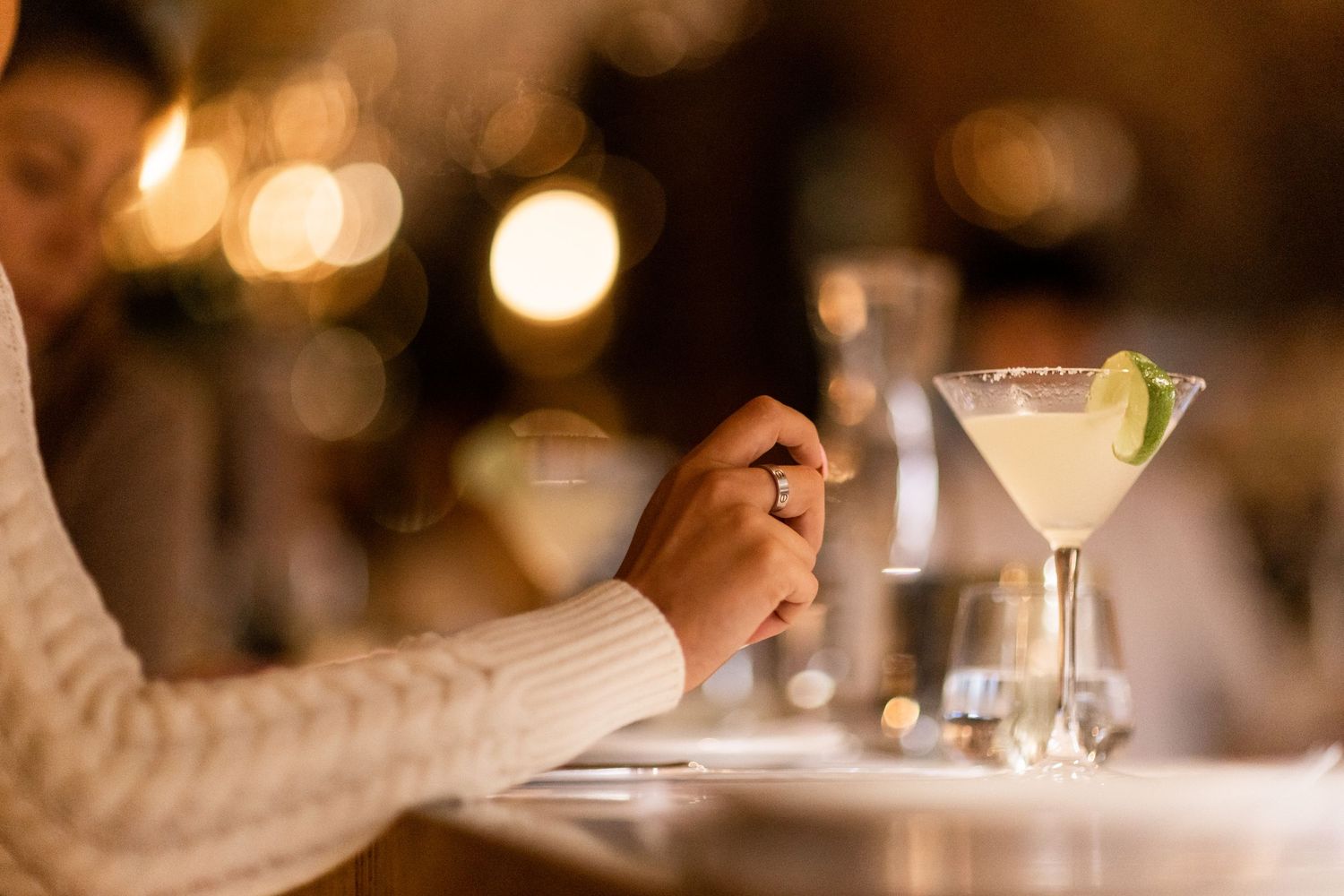 Blurred cocktail glasses in warm restaurant lighting creating bokeh effect.