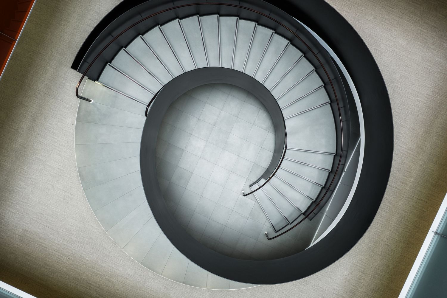 Spiral staircase viewed from above creating a dramatic circular pattern.