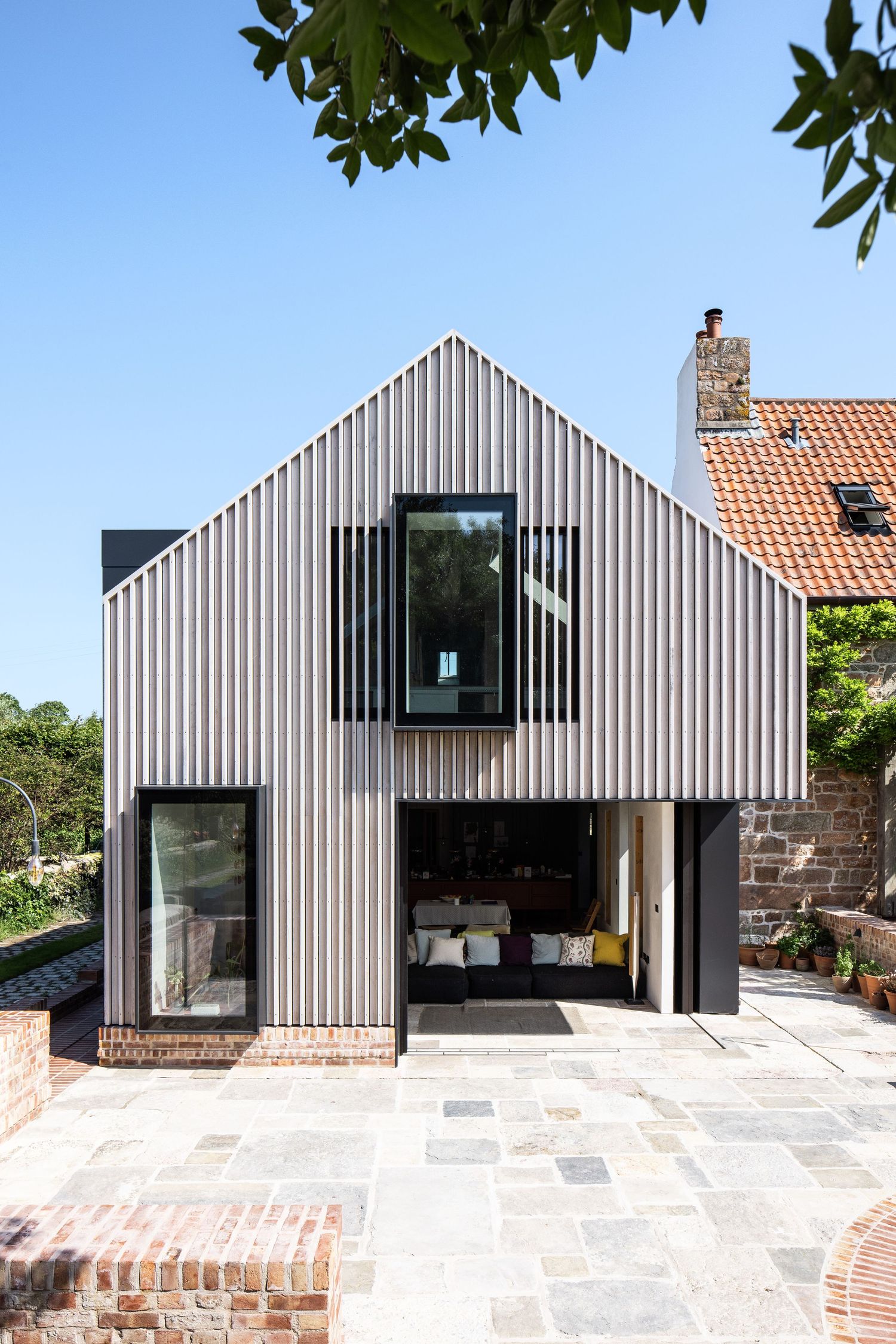 Row of modern gabled houses with vertical siding and minimalist design.
