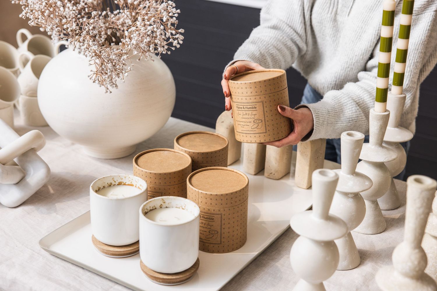 Collection of white ceramic vases and natural woven baskets on display.