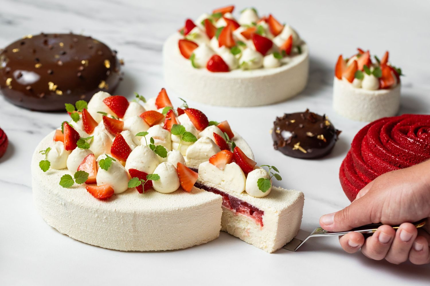 Various stages of decorating pavlova desserts with strawberries and cream.