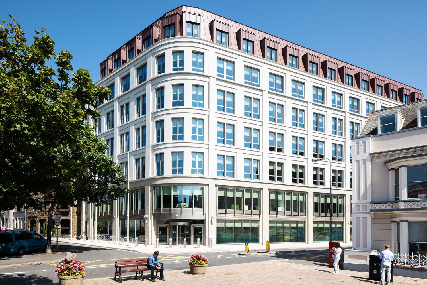 Large modern office building with blue-tinted windows and classic architectural details.