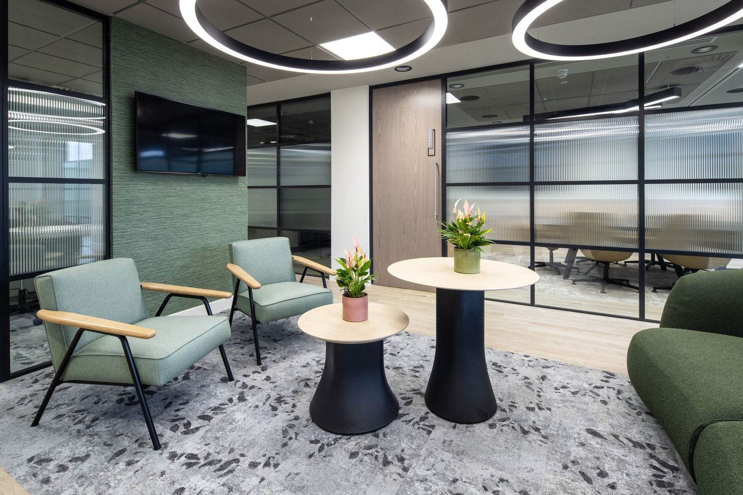Contemporary office interior with circular lighting fixtures and speckled carpet design.