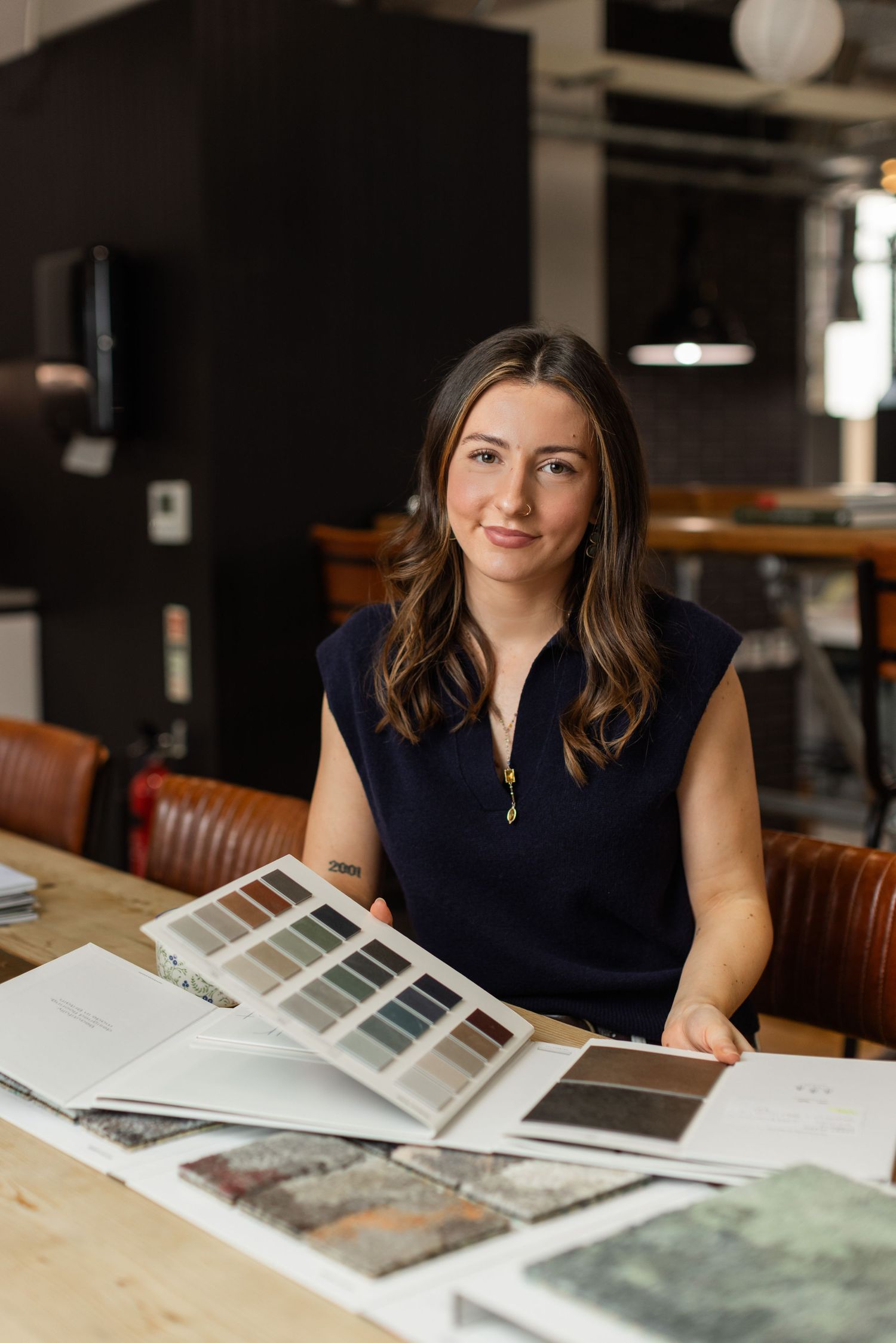 Interior designer at Axis Mason reviewing color and material swatches at a workspace.