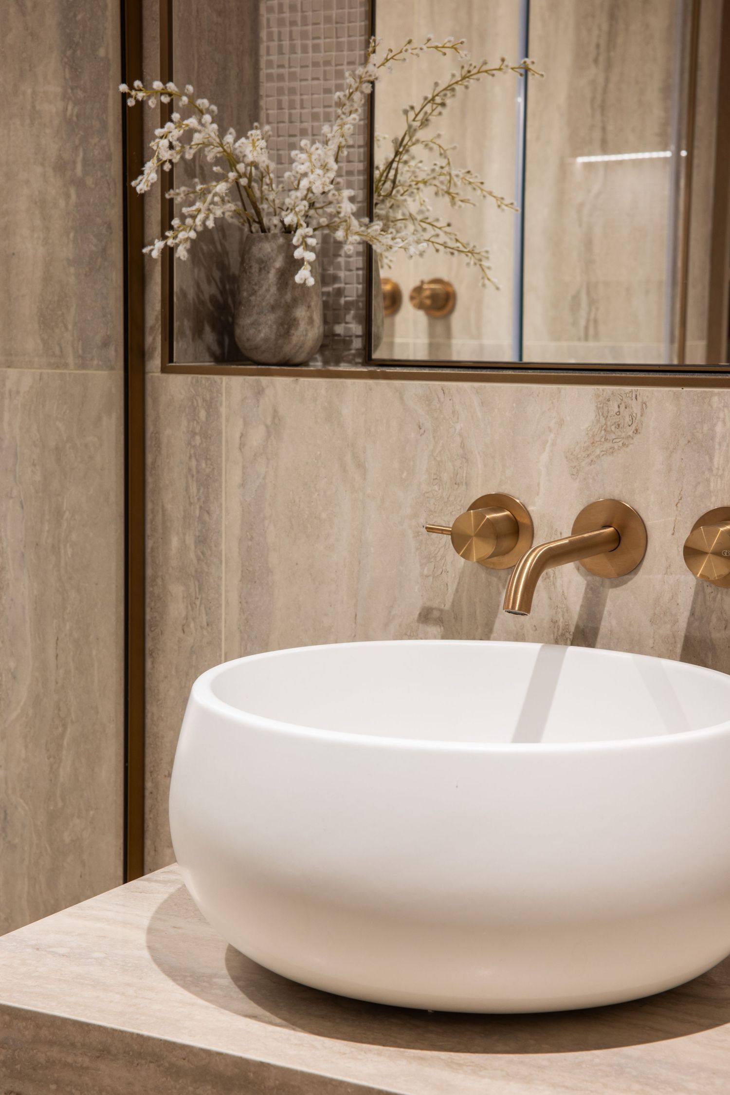 Minimalist bathroom vanity with white vessel sink and wooden accents.