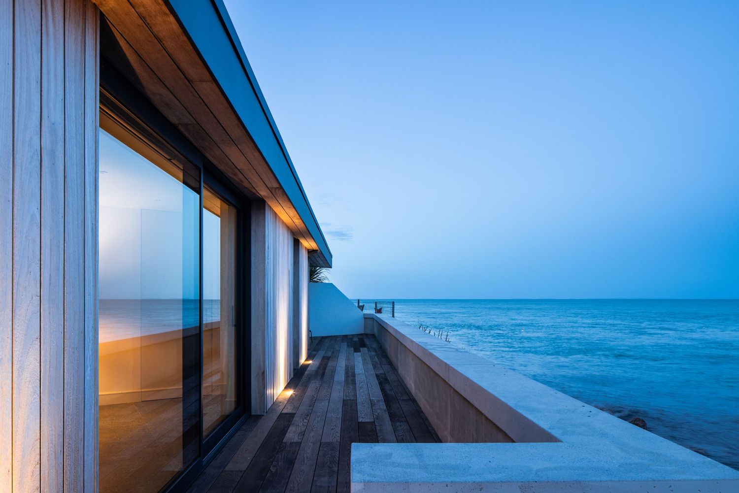 Panoramic view of ocean horizon through modern architectural windows with wooden details.