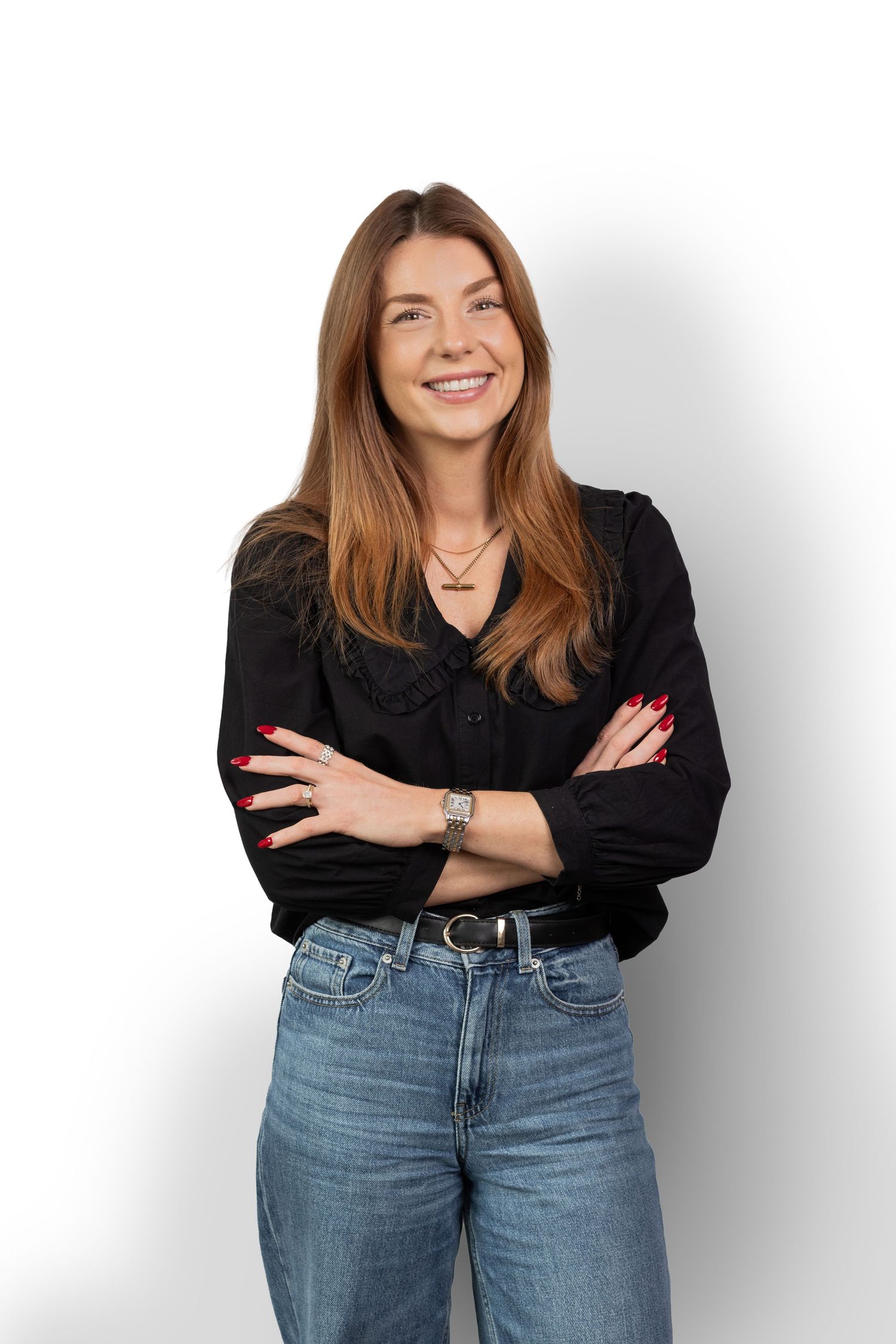 Woman in black top and jeans posing against white background in casual studio portraits.