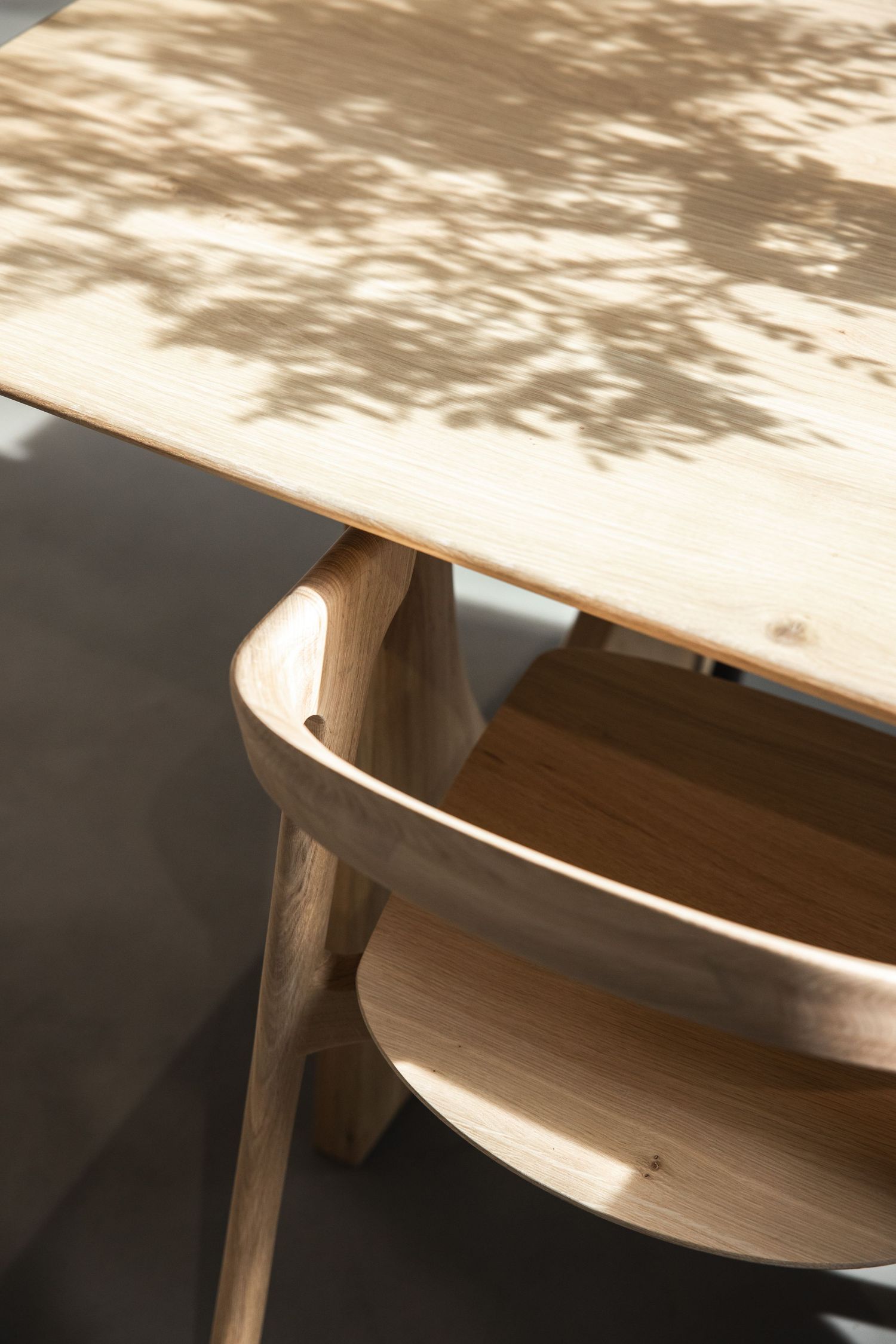 Sunlit wooden table surface with dramatic shadow patterns.