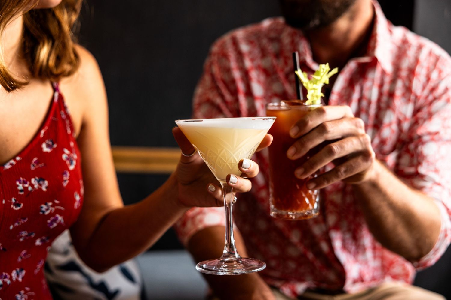 Various elegant cocktails being served in stylish glassware at an upscale bar.
