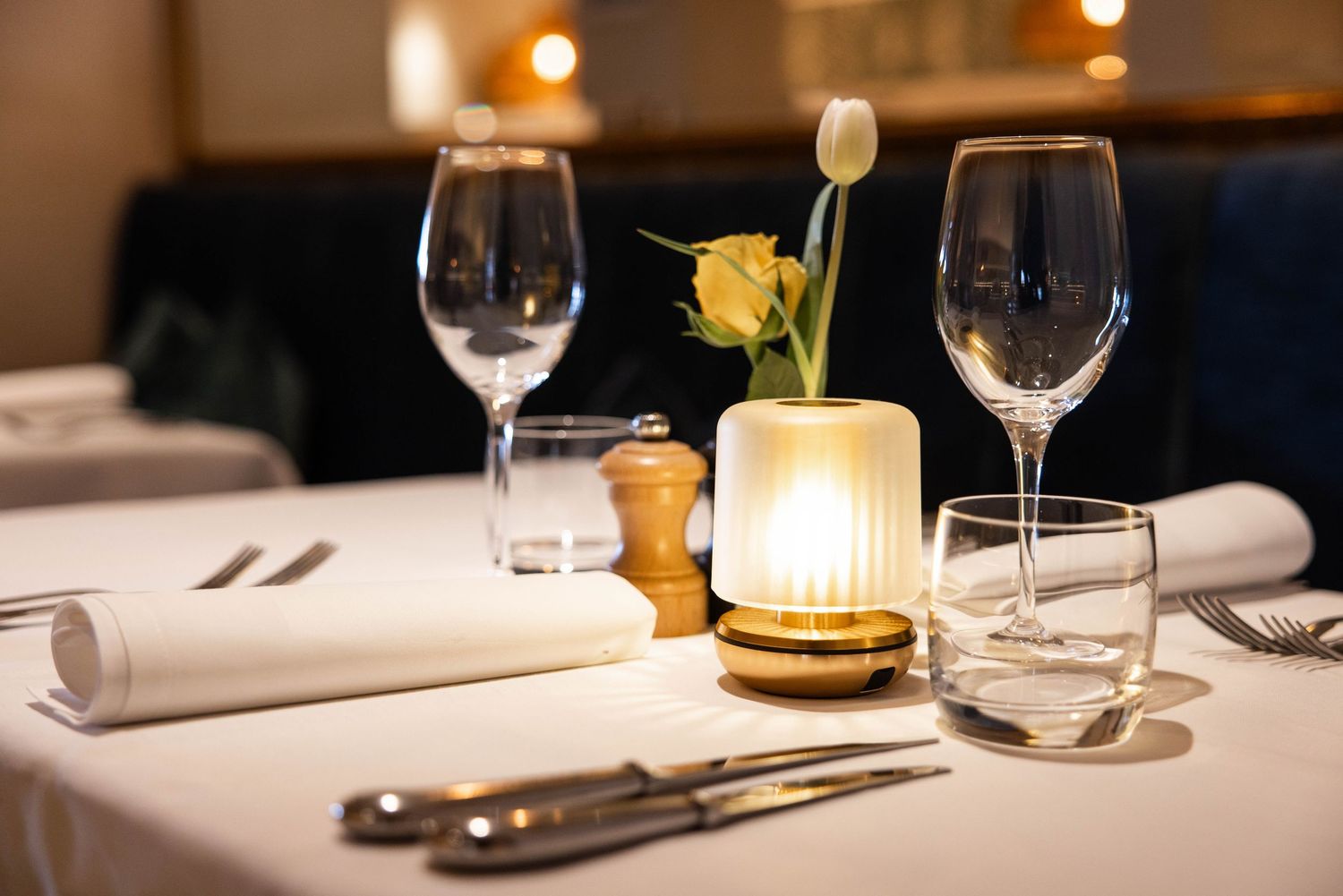 Elegant fine dining table setting with wine glasses and ambient lighting in an upscale restaurant.