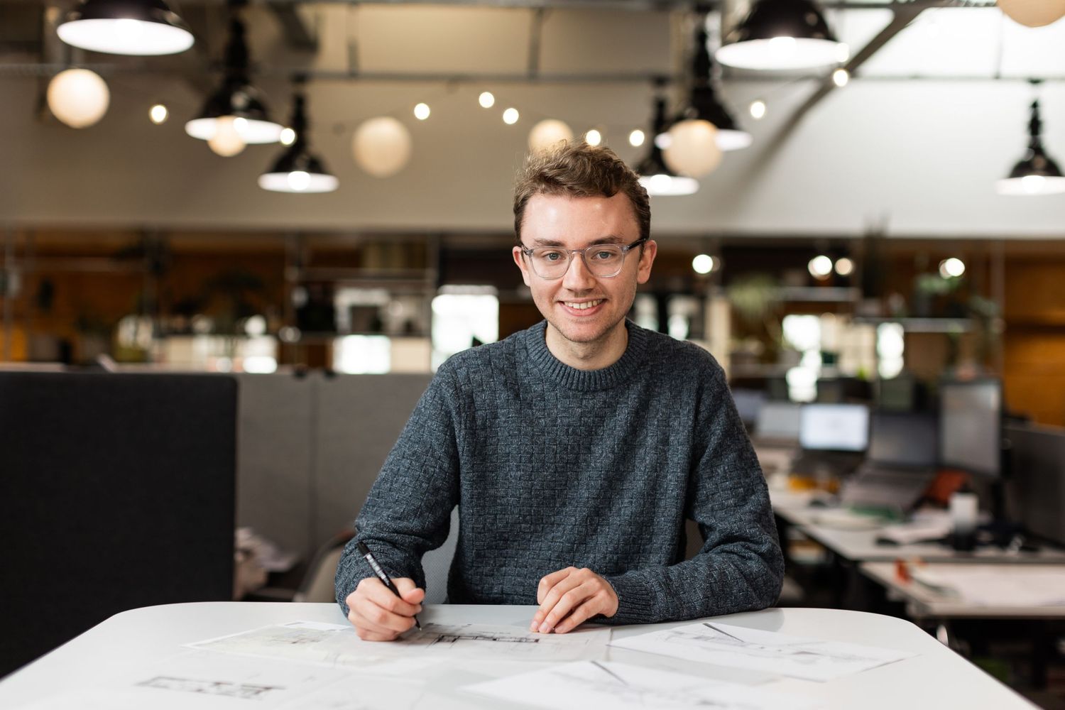 Team member at Axis Mason working together at a well-lit modern office desk.