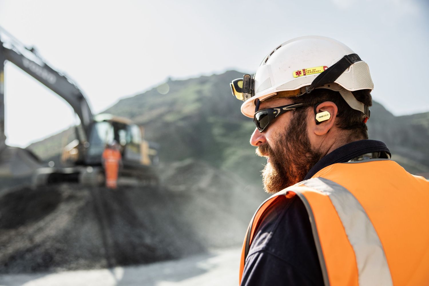 Construction supervisor in safety vest and hard hat at mining site.