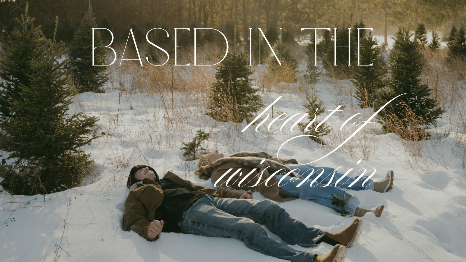 Couple lies in snow surrounded by pine trees with text reading Based in the Heart of Wisconsin.