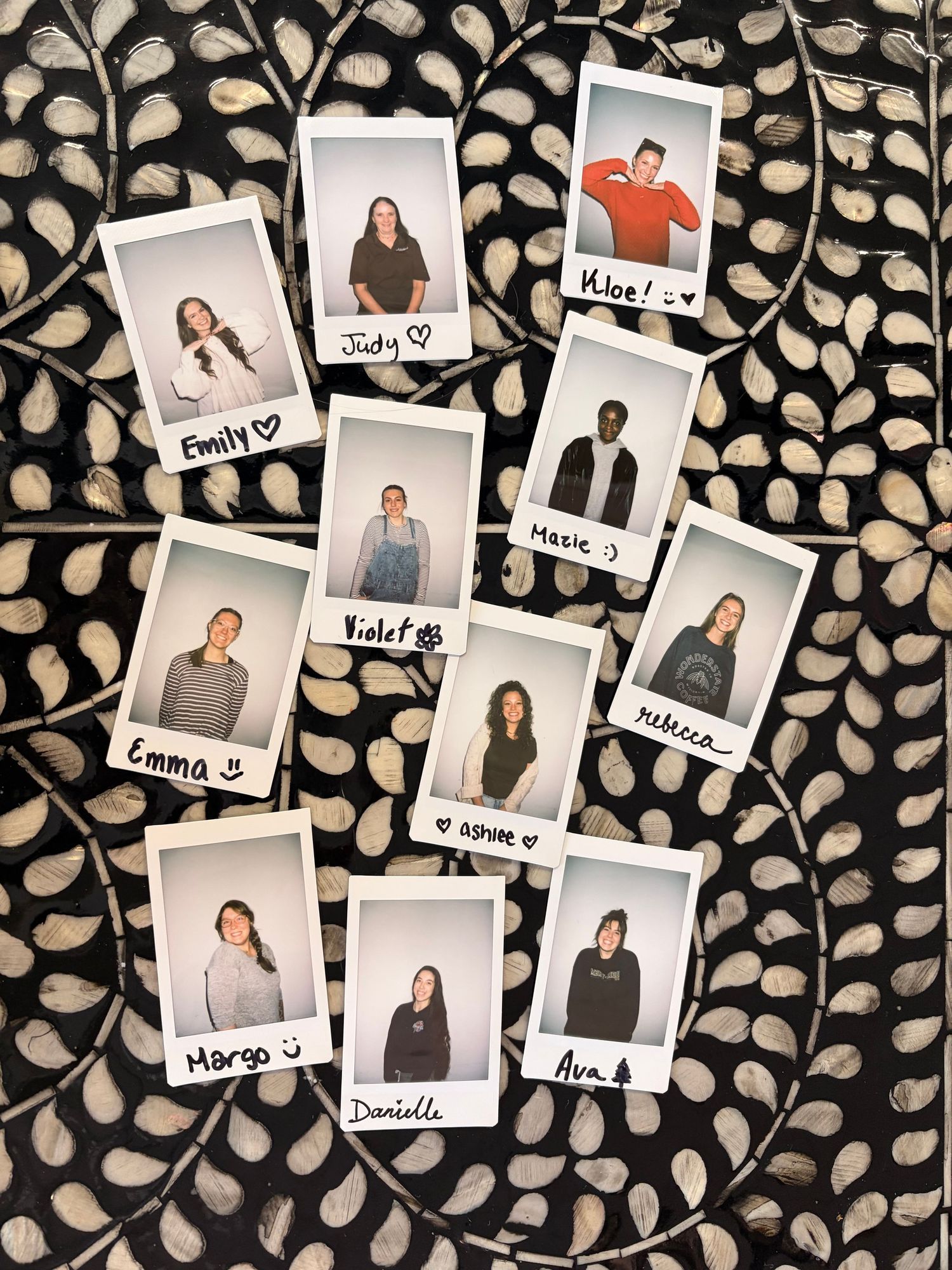 Collection of labeled Polaroid photos arranged on decorative black and white patterned background.