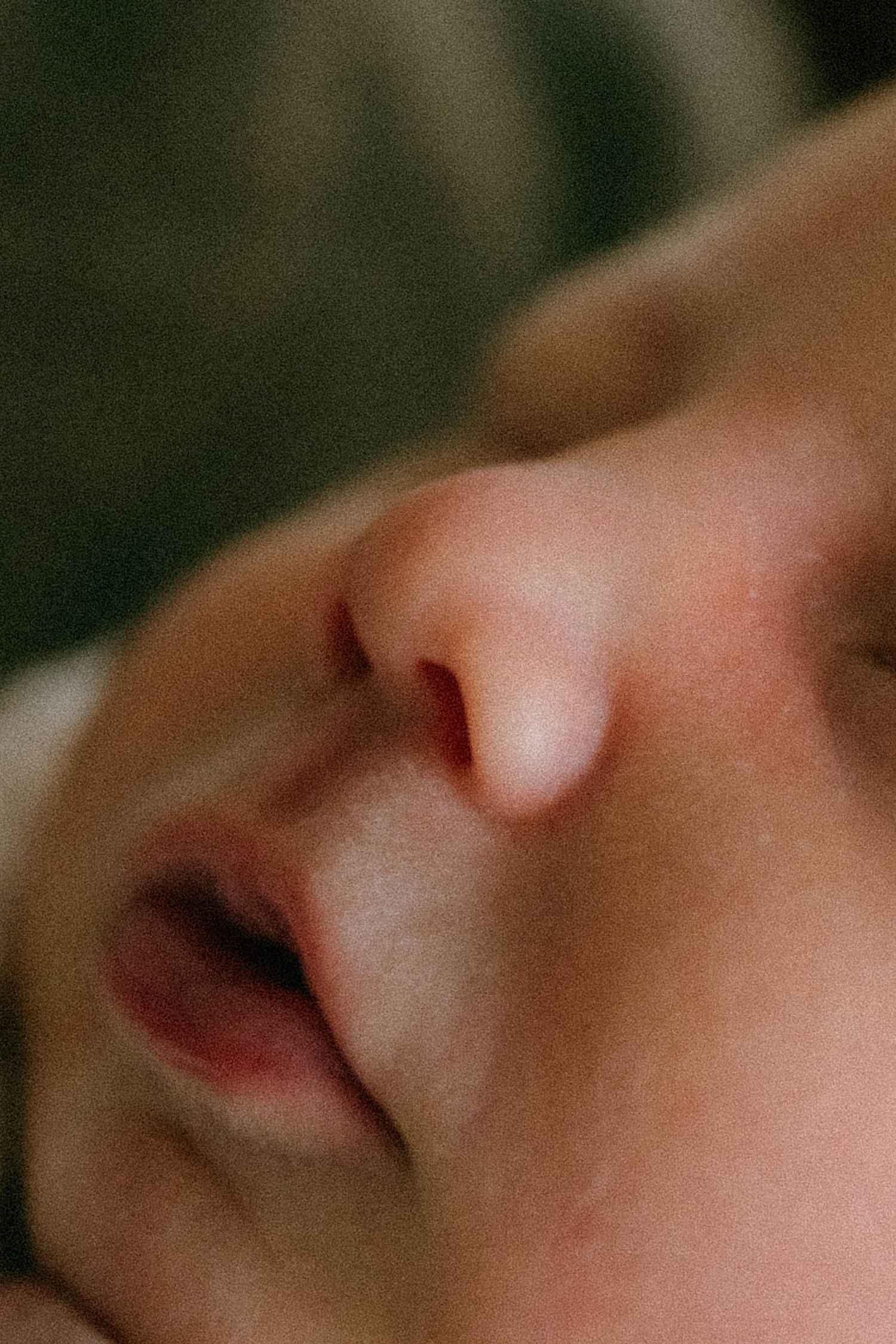 Extreme close-up macro portrait of peaceful sleeping newborn baby face.