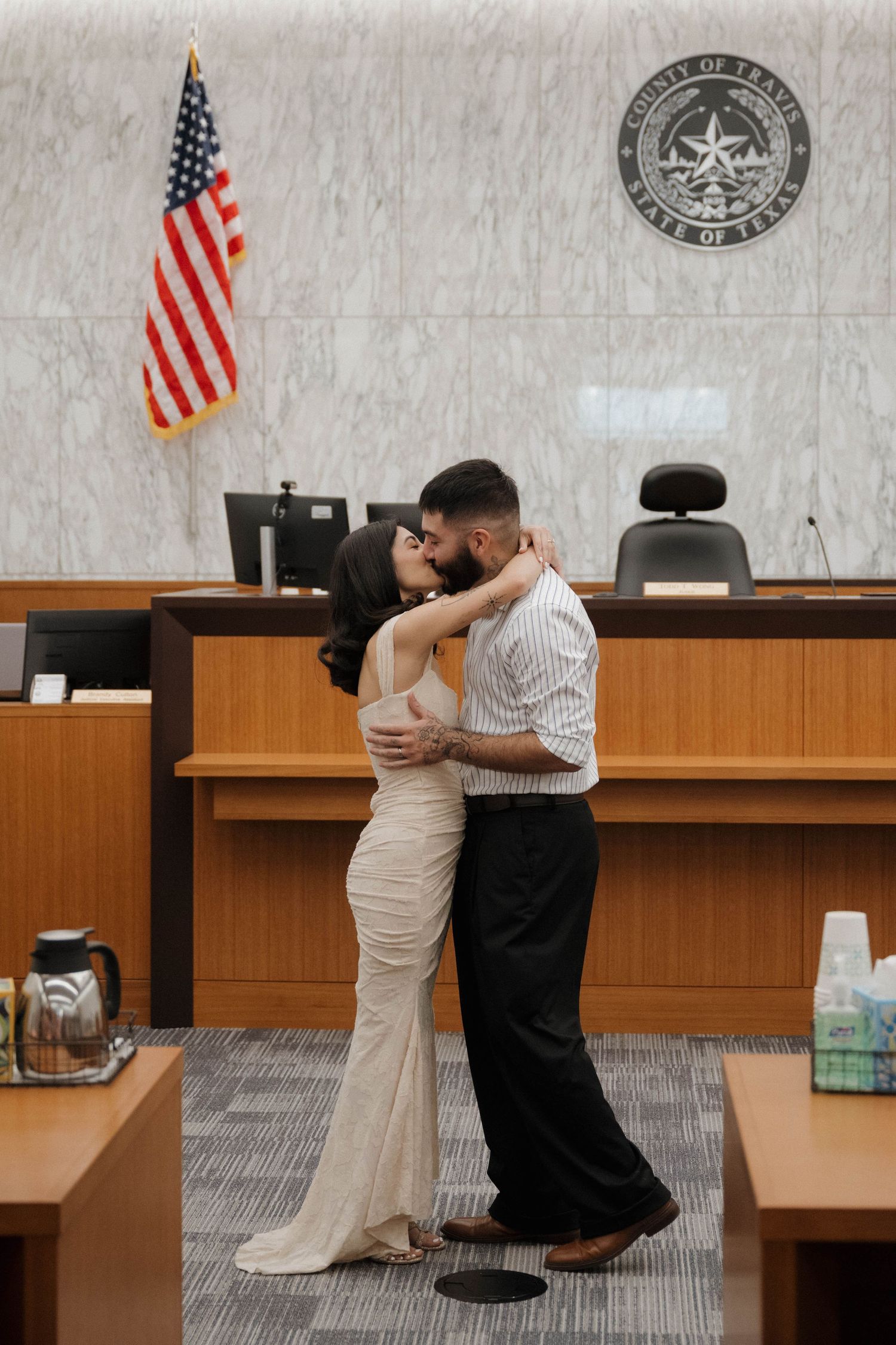 Couple sharing a first kiss as newlyweds inside a Travis County Texas courthouse.