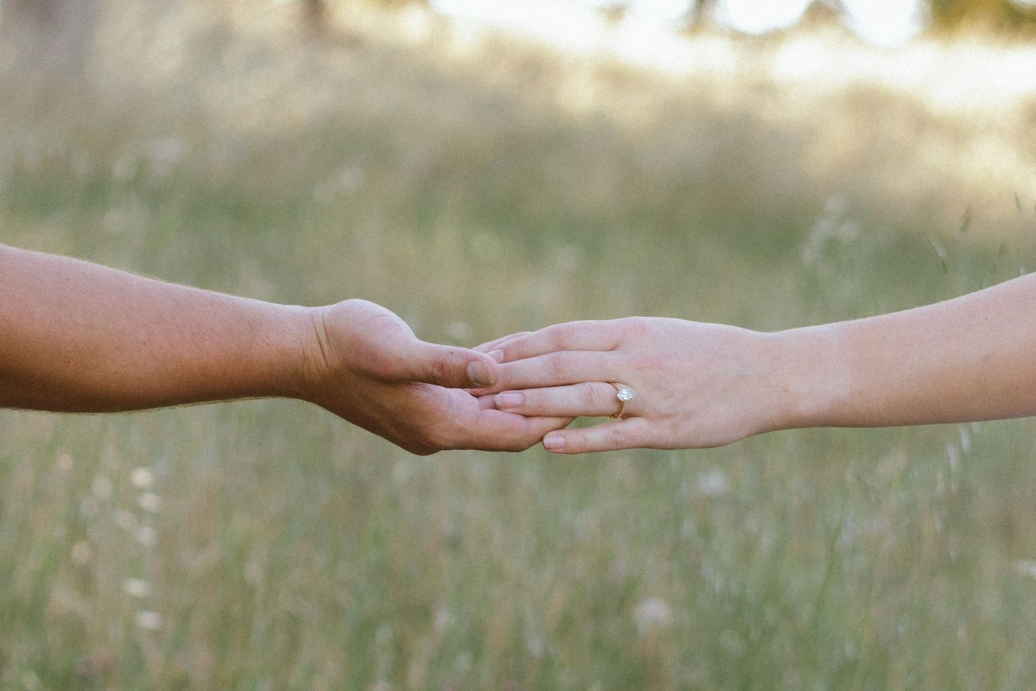Close-up sequence of hands reaching out and touching in gentle connection.