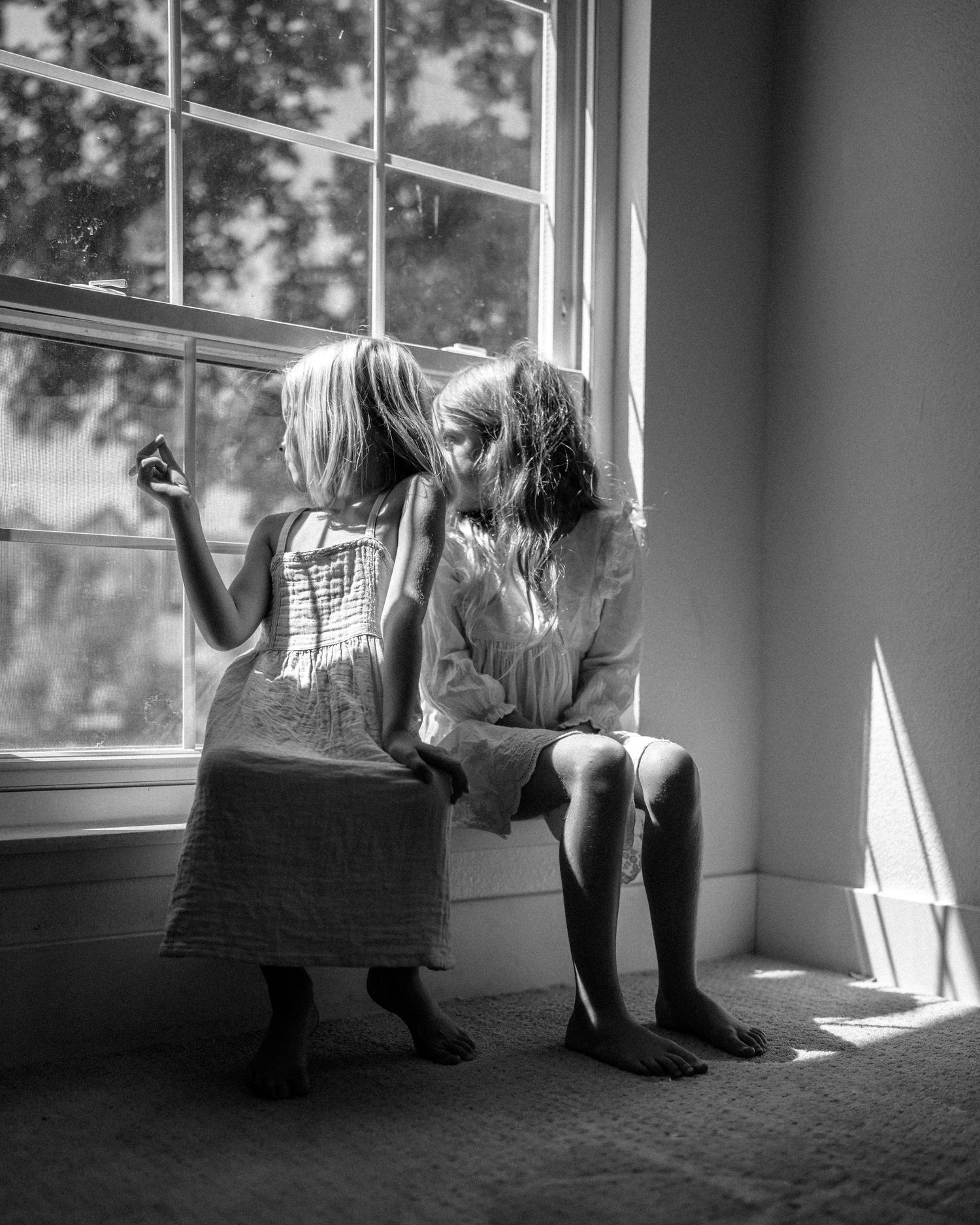 Black and white photos showing silhouettes sitting by large windows with dramatic lighting.