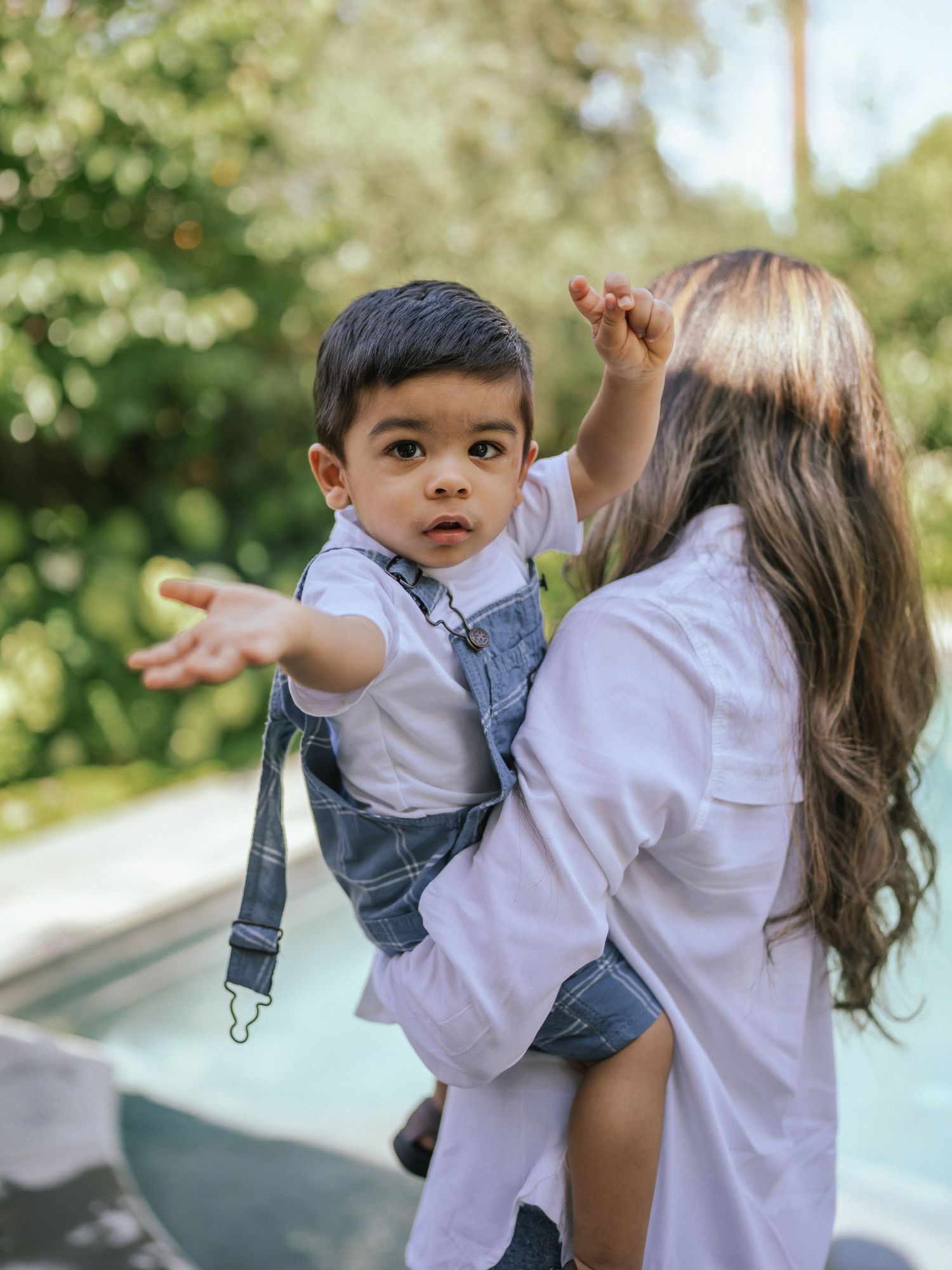 A playful moment captured between parent and child by a pool.