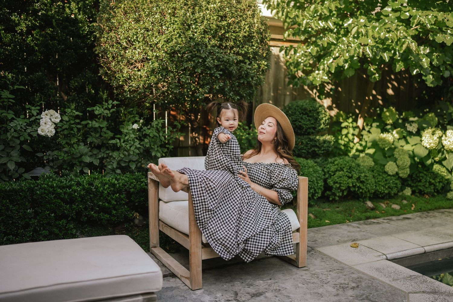 Outdoor garden bench scene with dappled sunlight and lush greenery in the background.