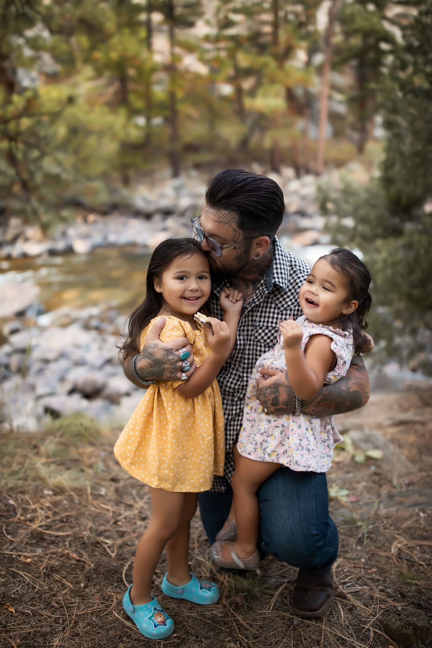 Family sharing joyful moments outdoors in a wooded setting during sunset.