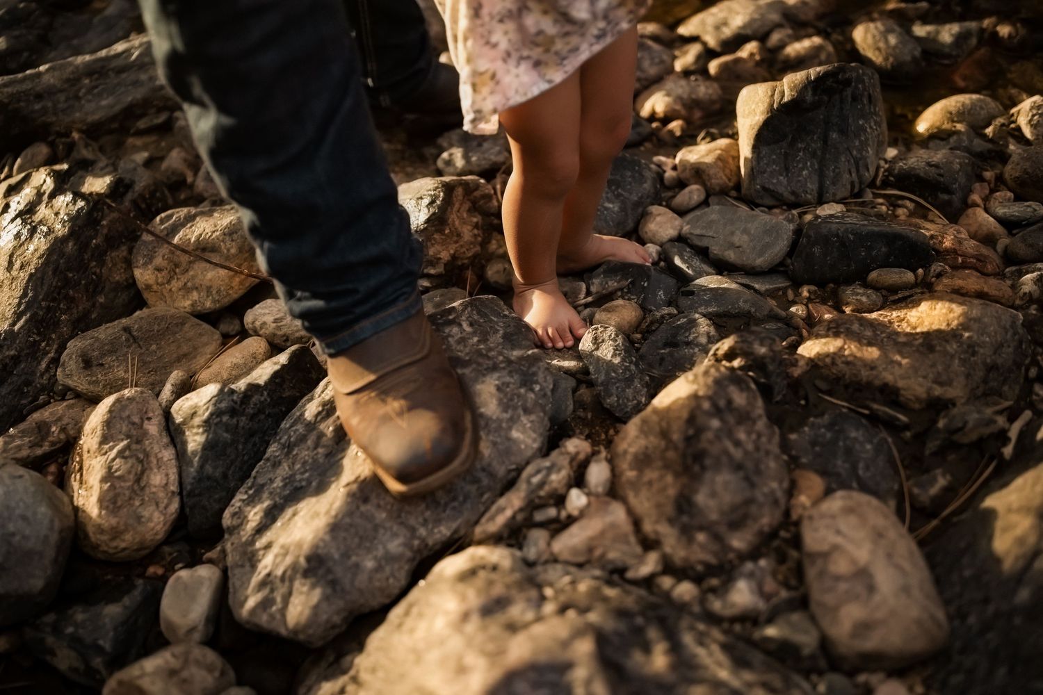 Rocky shoreline with sunlight casting shadows on rough stone terrain.