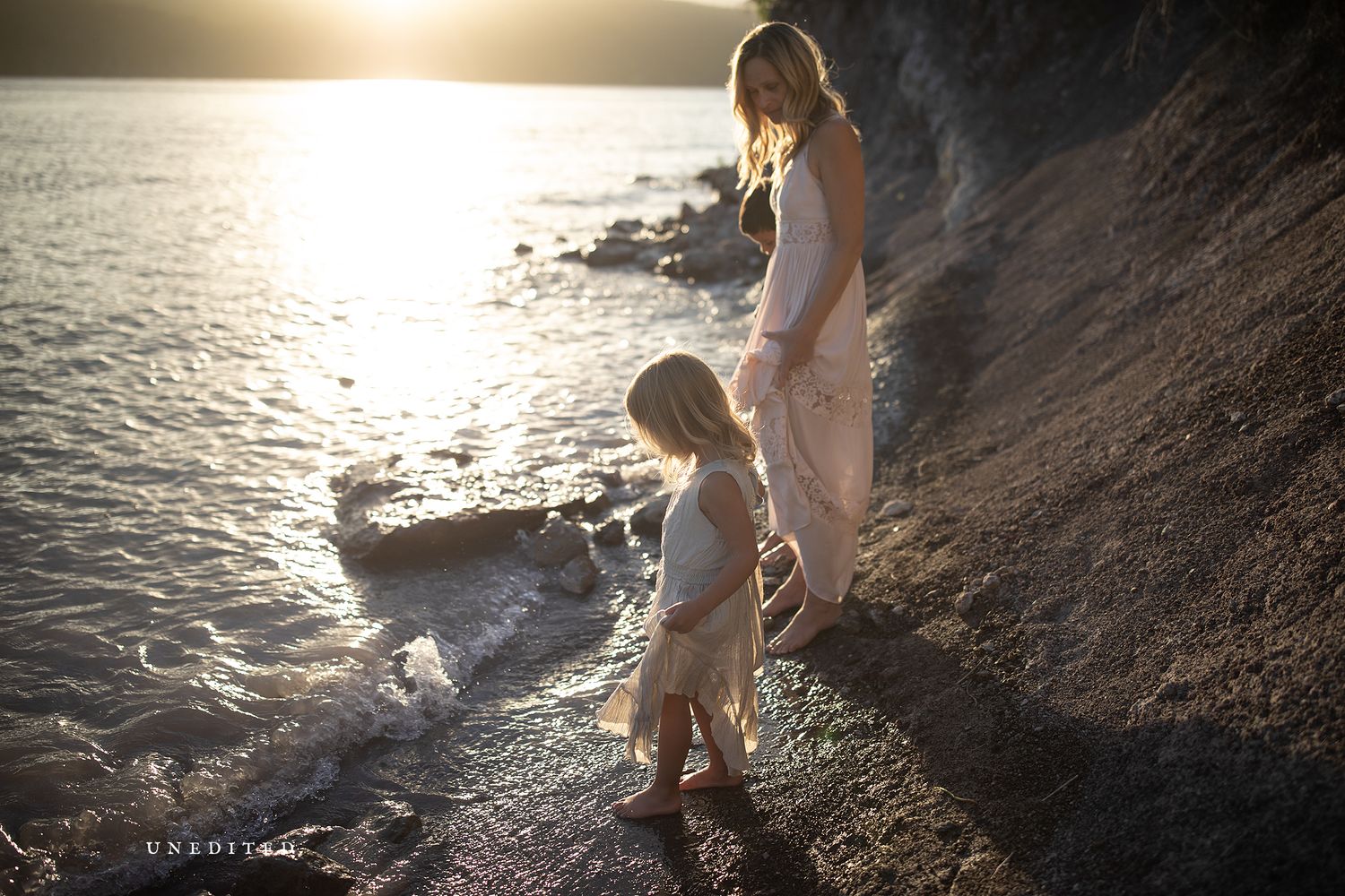 Artistic silhouette photography of people by the water's edge at sunset.