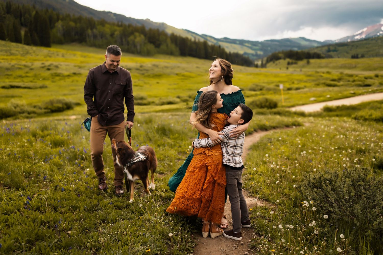Family enjoying a picturesque mountain meadow on a sunny afternoon in the rolling green hills.