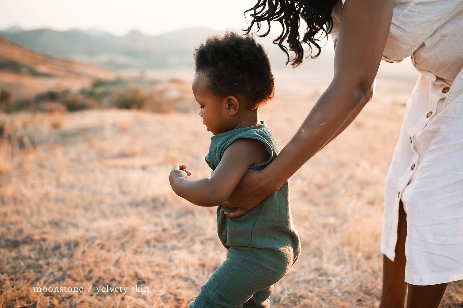Intimate family moments captured in warm sunset light on grassy terrain.