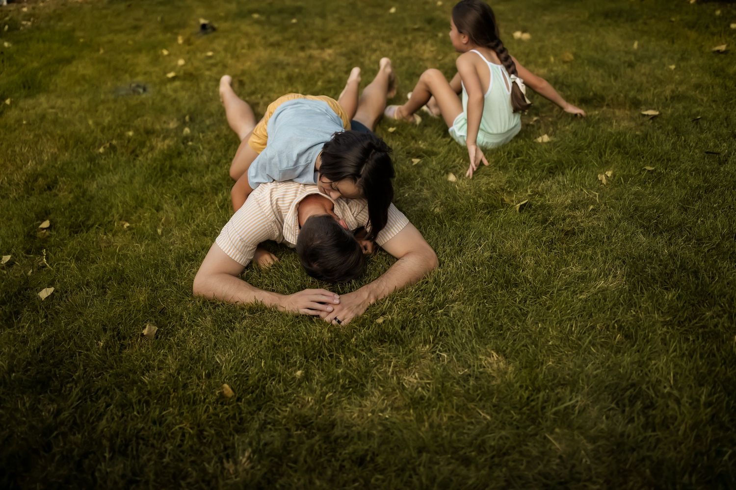 People lounging on green grass during a warm summer day in the backyard.