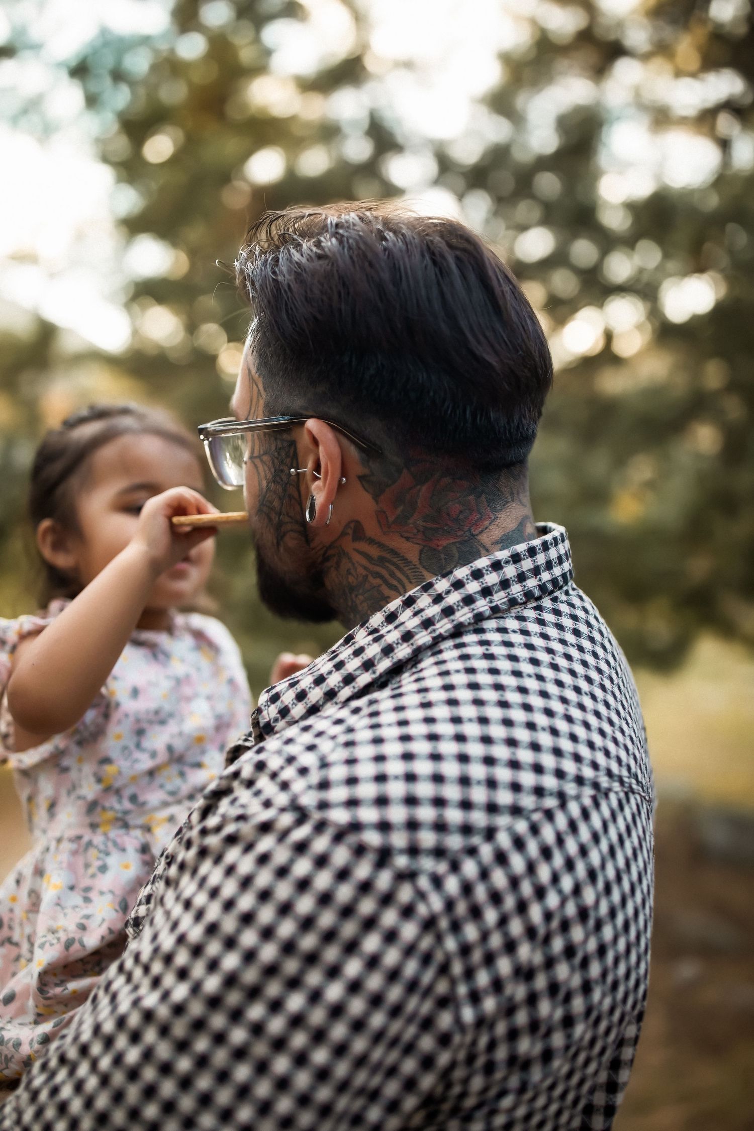 Tender interaction between parent and child against blurred natural background.