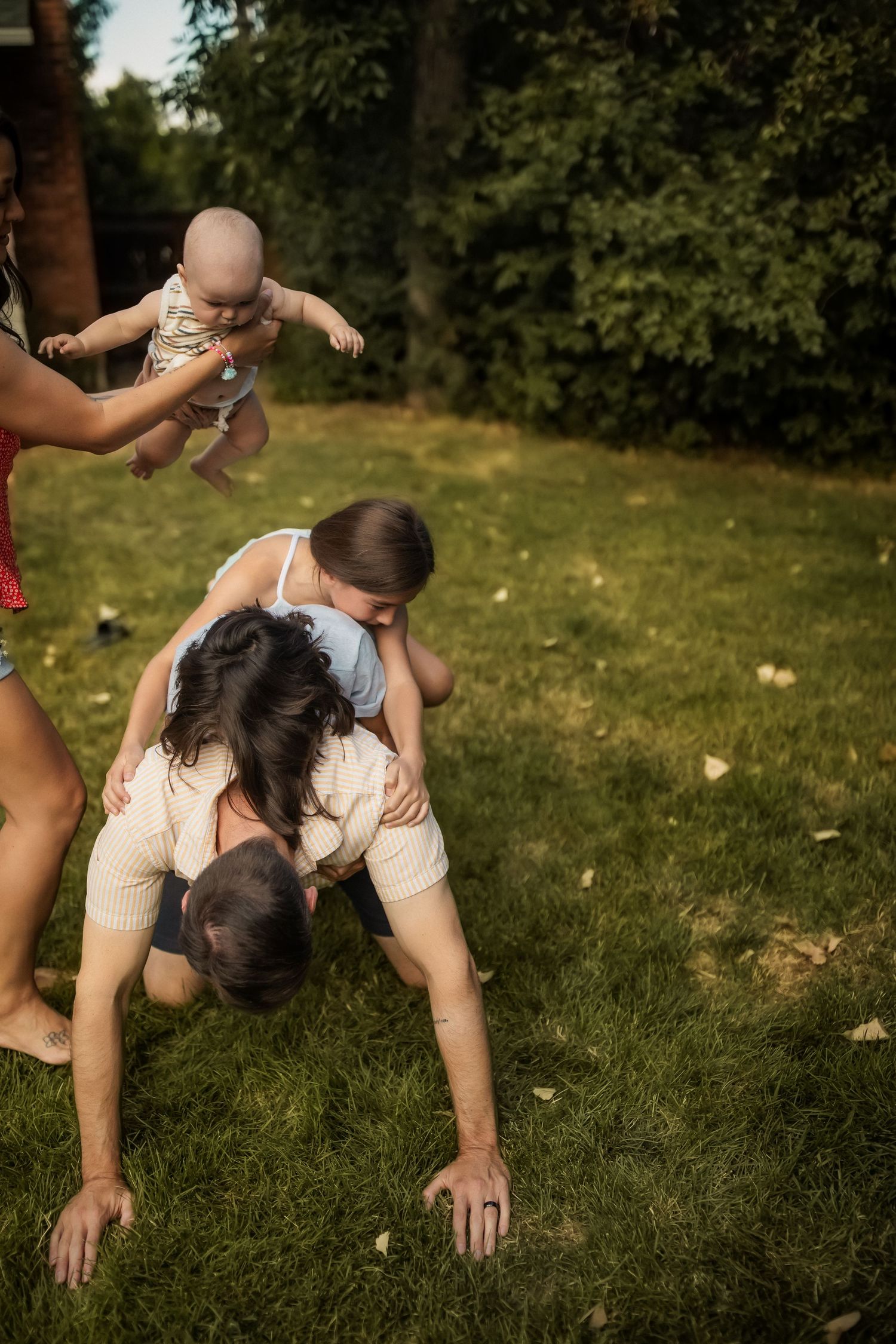 A sequence showing a couple tumbling and playing together on green grass.