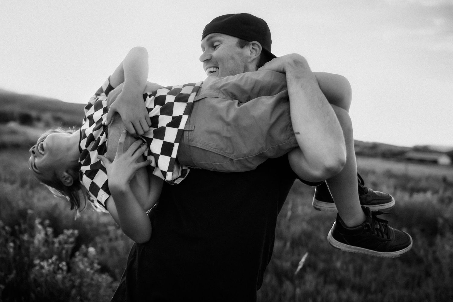 Playful black and white portraits captured in an outdoor setting.