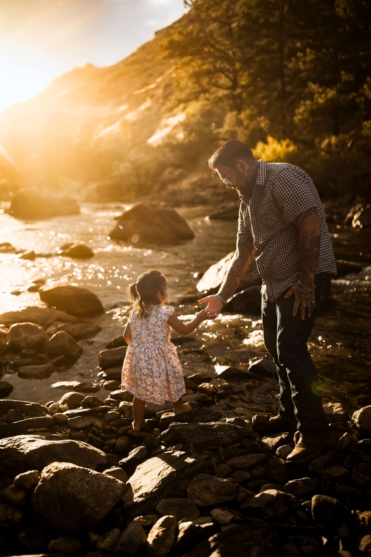 People exploring rocky coastline during golden hour sunset.