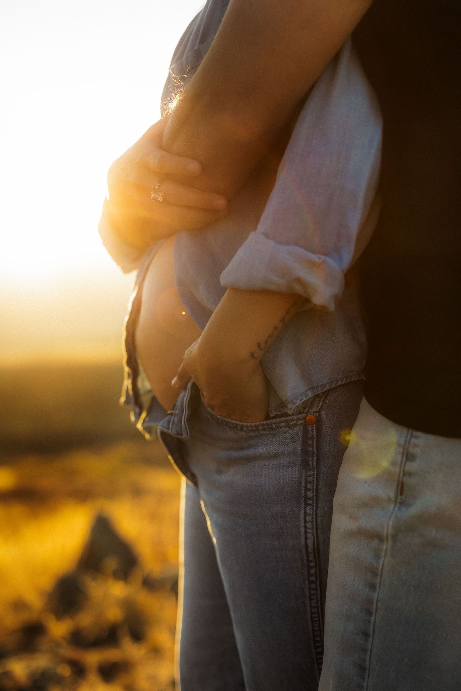 Silhouette of two people embracing against a golden sunset backdrop.