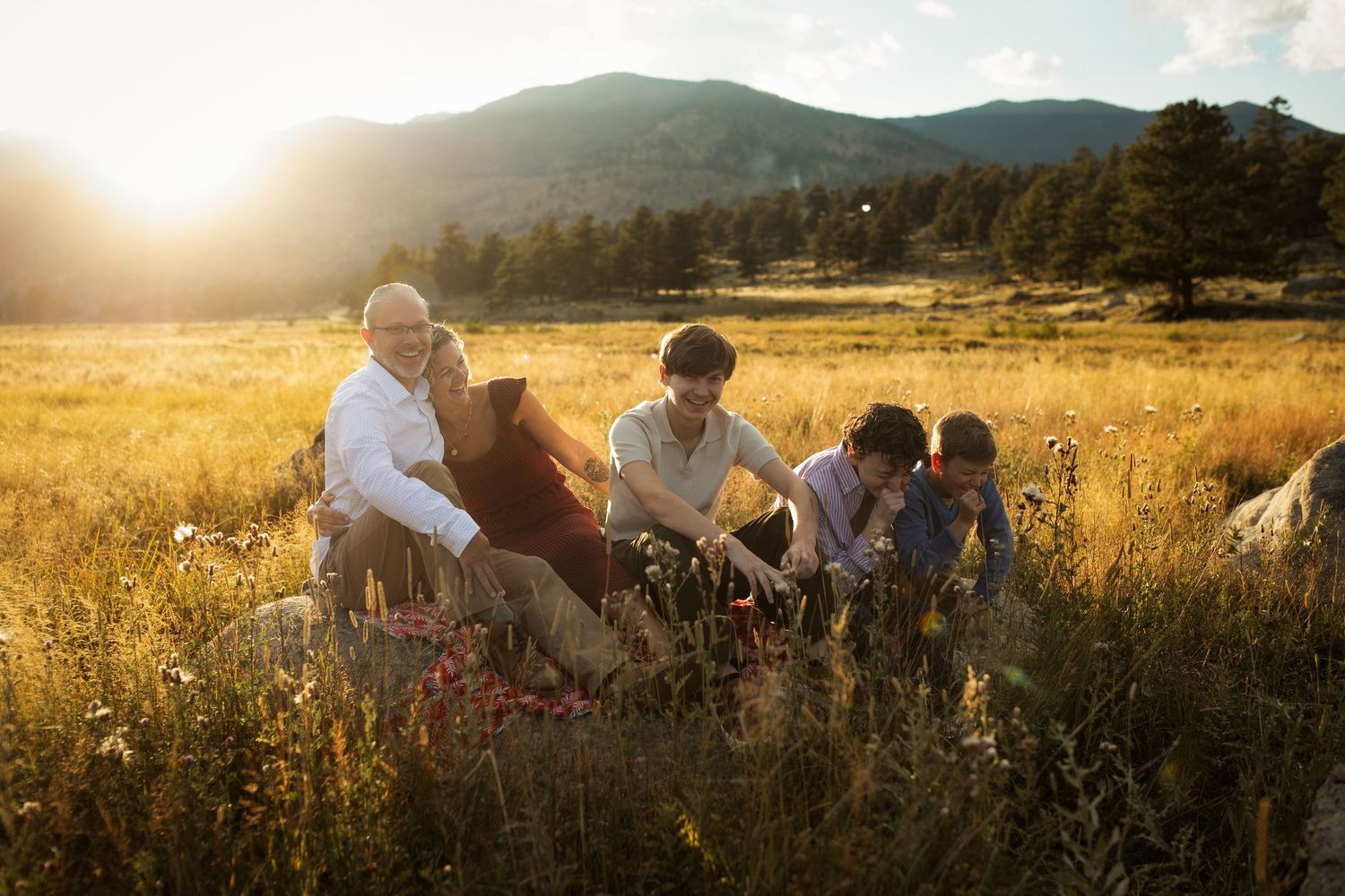A group enjoying a sunset picnic in a golden mountain meadow.